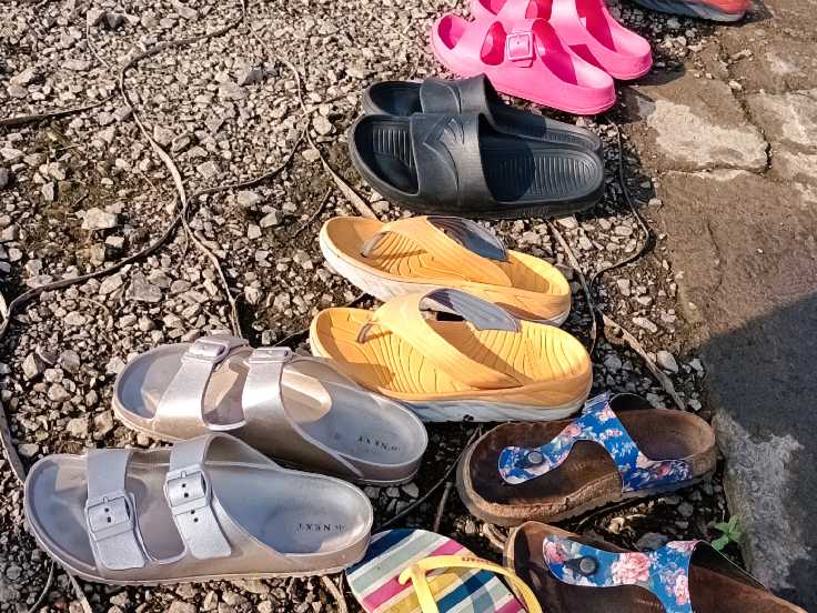 a selection of slip on footwear on the beach area
